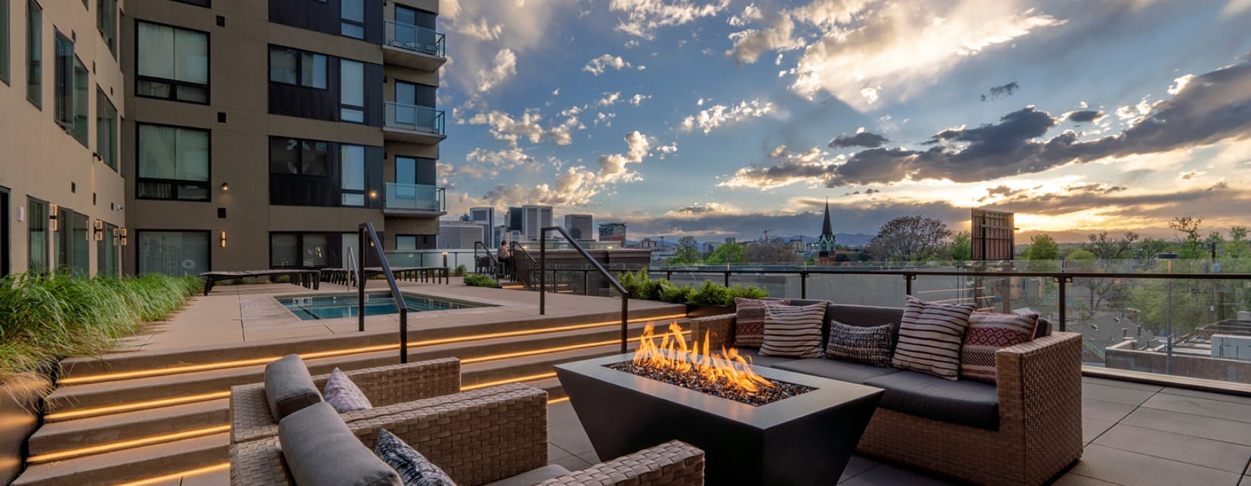 fire pit and sitting area on rooftop lounge with city views
